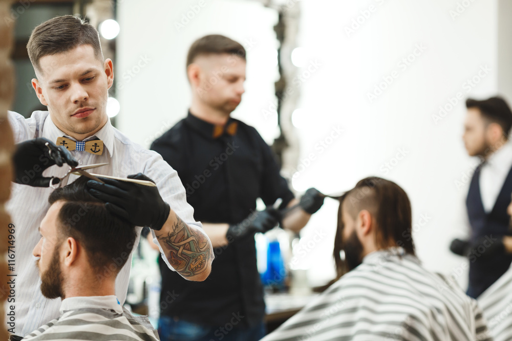 Barbers doing haircuts for clients