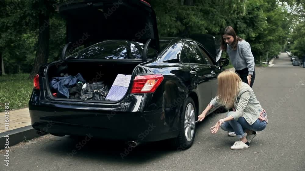 Woman driver trying to remove wheel with wrench Woman driver trying to remove wheel with wrench
