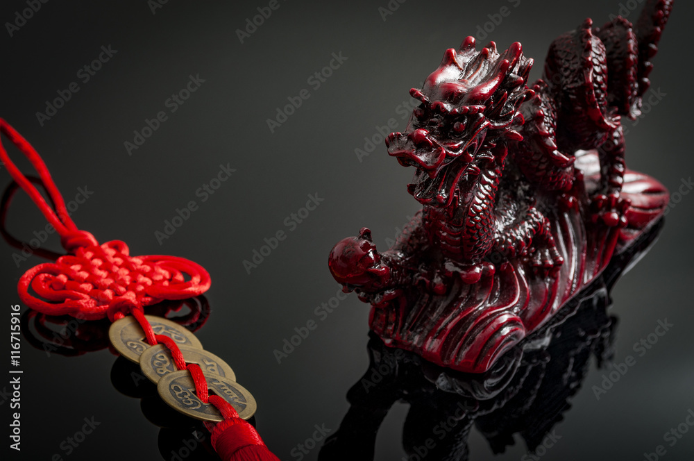 Naklejka premium Wealth and power symbolized by the fengshui coins charm and the asian mystic dragon. Feng Shui is a Chinese philosophical system of harmonizing everyone with the surrounding environment