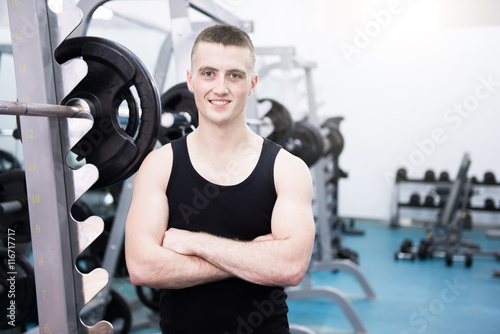 Athletic man with a dumbells in gym