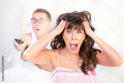 Frustrated Woman and Man in Bed with Watching TV