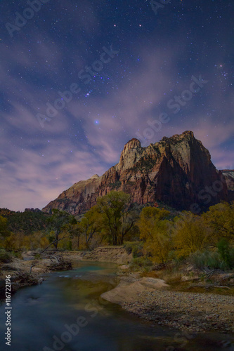 Scenic view of river passing through forest against starry sky photo