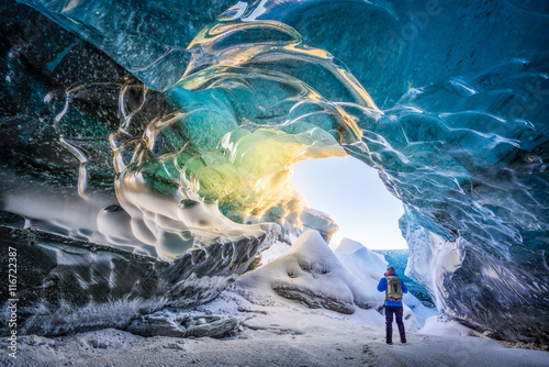 Hiker exploring ice cave, iceland photo