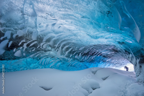 Hiker exploring ice cave, iceland