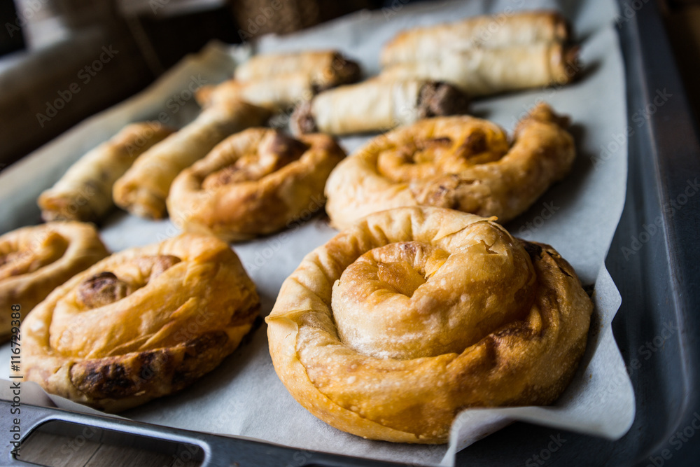 strifti pita borek with cheese, spinach or leek on a tray strifti pita borek with cheese, spinach or leek on a tray
