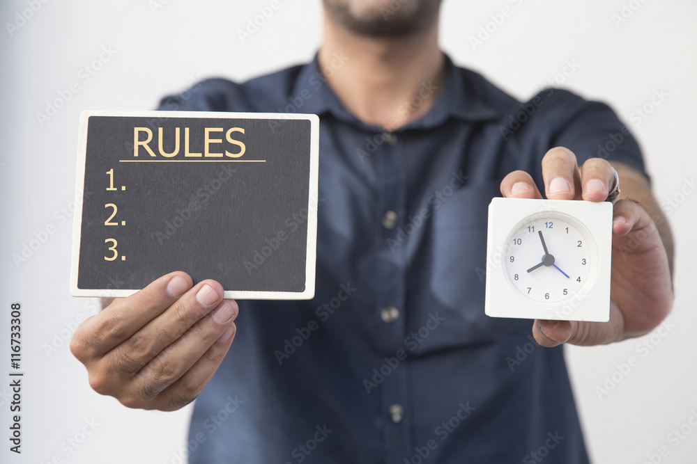 man holding chalkboard and clock with RULES message, man holding chalkboard and clock with RULES message,