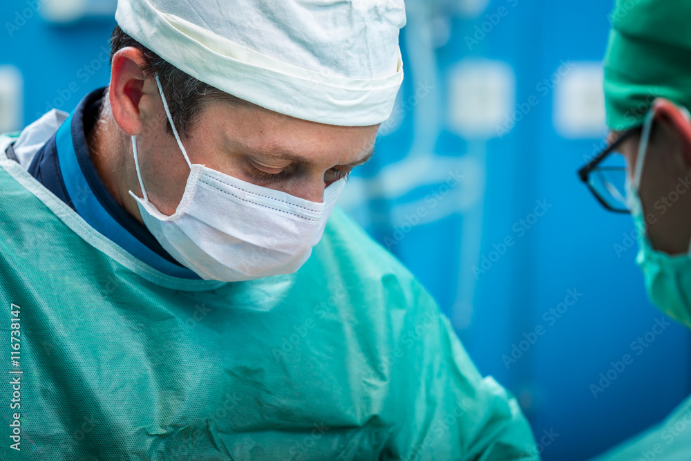 Orthopedic surgeon portrait while operating and focusing on his Orthopedic surgeon portrait while operating and focusing on his