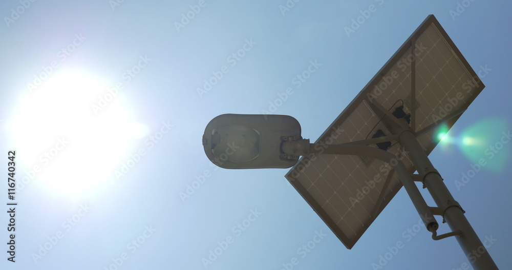 Low-angle shot of street lighting lamp working from the solar cell battery made in sunny day. Low-angle shot of street lighting lamp working from the solar cell battery made in sunny day.
