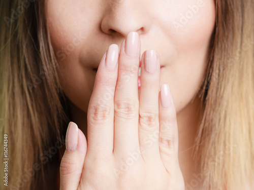 Part of face woman covering her mouth with hand photo