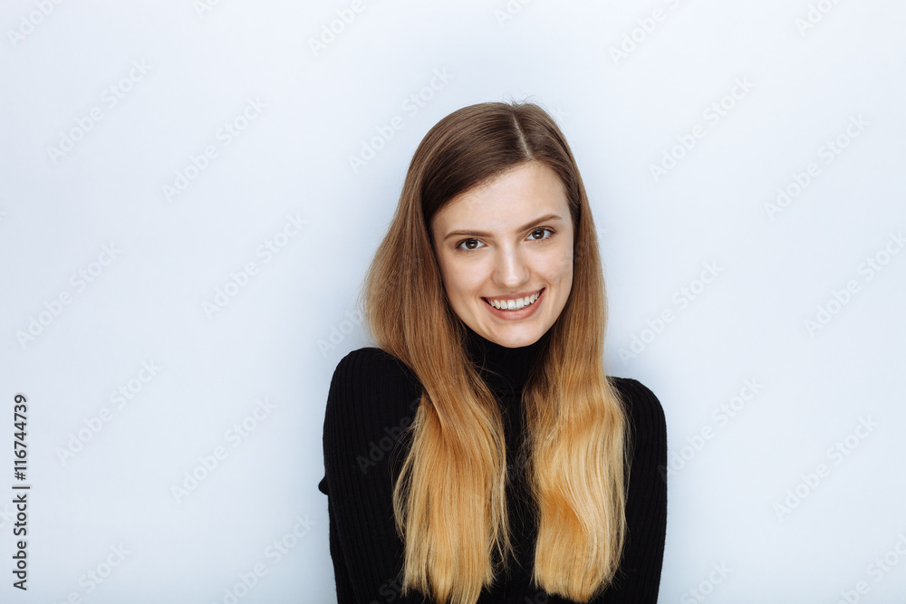 Portrait of happy smiling young beautiful woman in black sweater posing against white studio background Portrait of happy smiling young beautiful woman in black sweater posing against white studio background