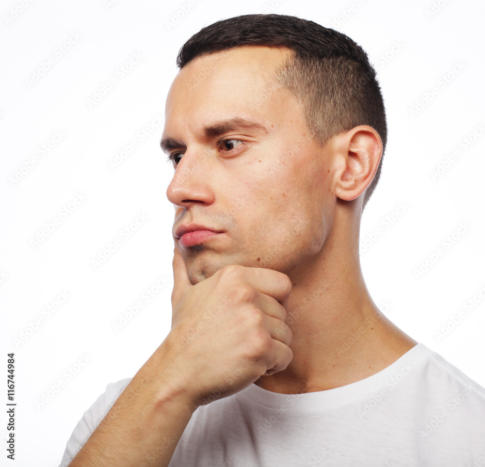 Fototapeta premium Portrait of handsome young thoughtful man isolated over white ba