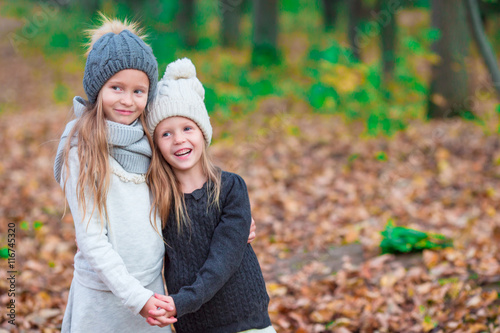 Little adorable girls outdoors at warm sunny autumn day