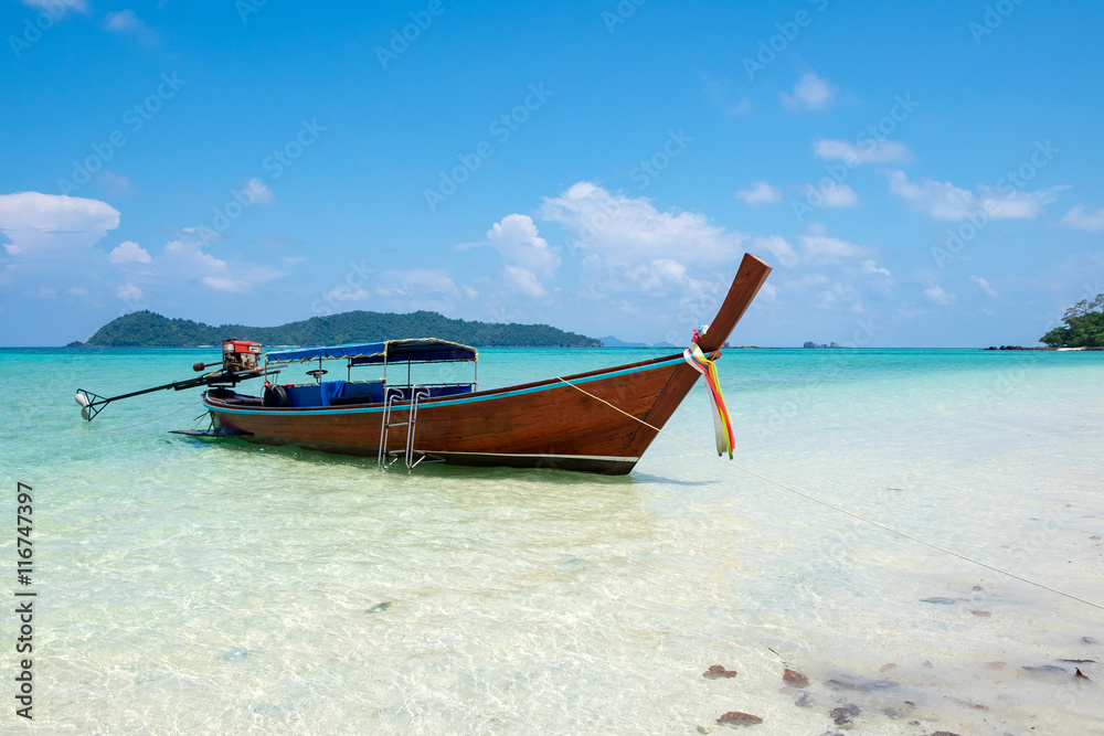 Long tail wooden boat anchor with csytal sea white sand at lipe island,andaman,thailand