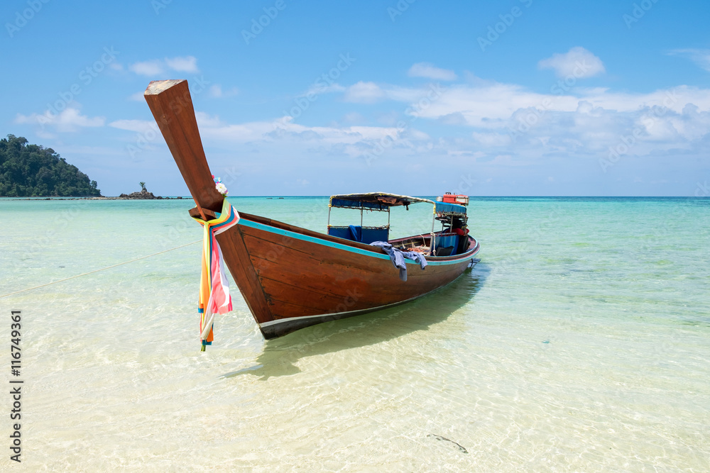 Long tail wooden boat anchor with csytal sea white sand at lipe island,andaman,thailand