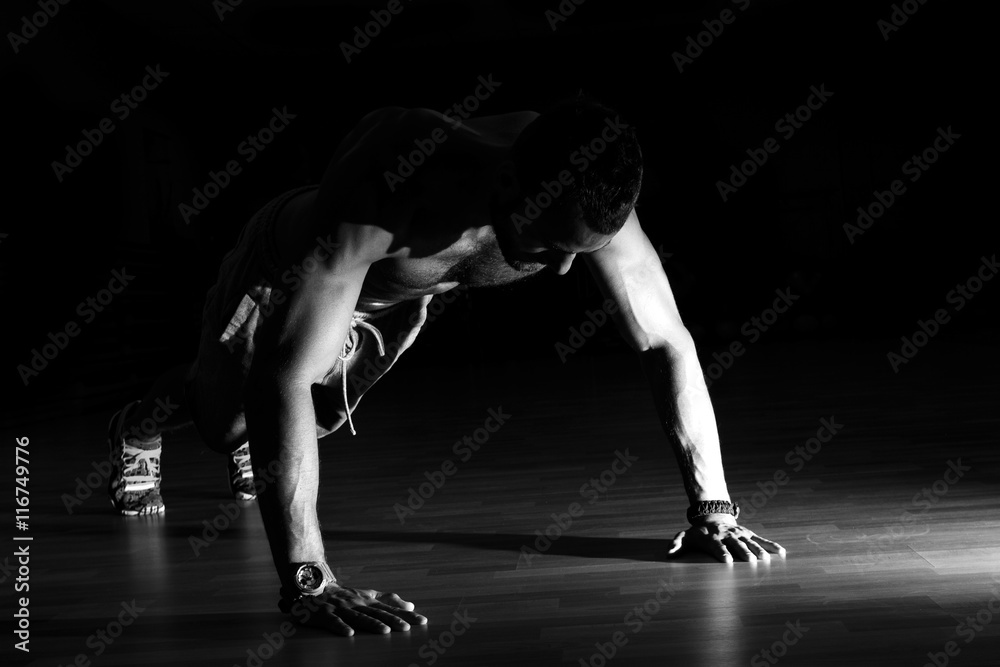 Man making burpees during strength training in gym. Man making burpees during strength training in gym.
