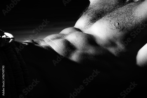 Naked man's chest in gym. Black and white photo.