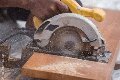Obraz na plátně carpenter use electric saw to sawing wood