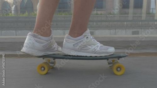 Legs of skateboarder to ride a skateboard on the road in the city
