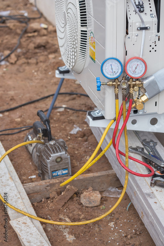Foto vacuum pump evacuates air from the air conditioner