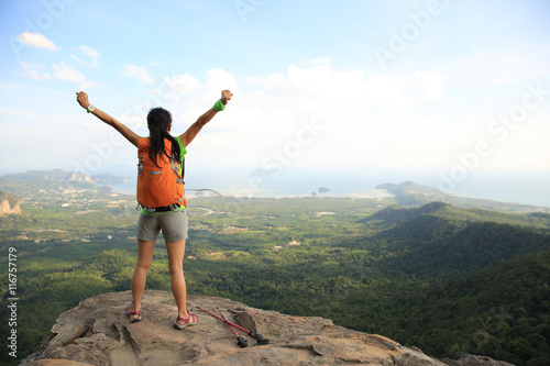 successful woman hiker enjoy the view at sunrise mountain peak