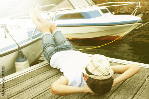 young man resting on the boat photo