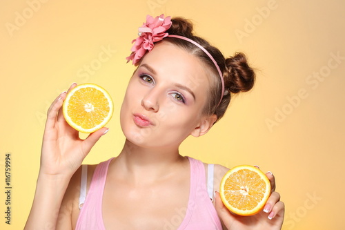 Joyful young woman holding juicy oranges