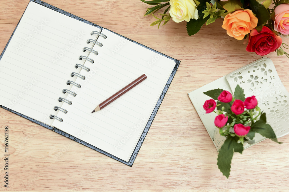 Pencil and open notebook on wood background in selective focus. Pencil and open notebook on wood background in selective focus.