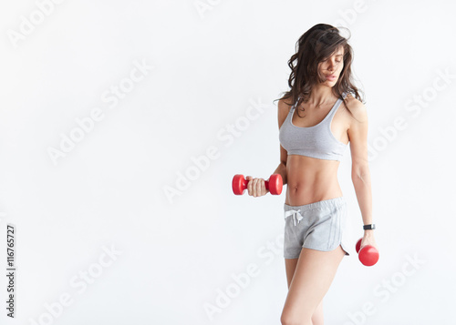 woman in fitness wear exercising with dumbbells