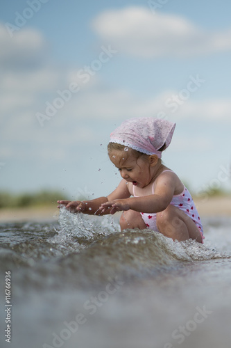 Fototapeta Naklejka Na Ścianę i Meble -  little girl playing on the beach