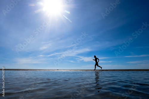 silhouette of man running on the beach