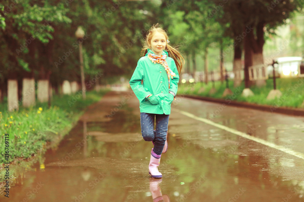 girl jumping in puddles spring rain girl jumping in puddles spring rain