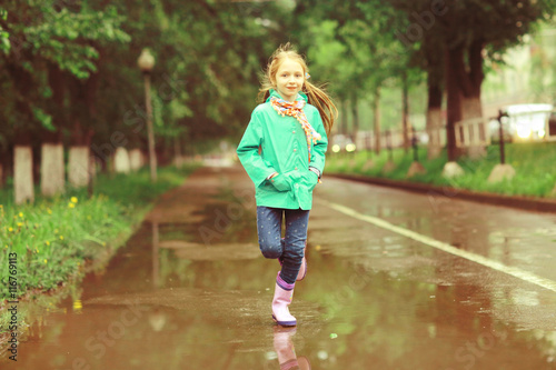 girl jumping in puddles spring rain