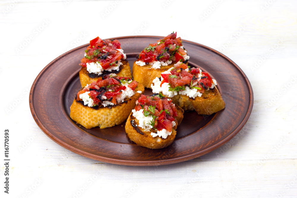 bruschetta with cheese and tomatoes on dark plate bruschetta with cheese and tomatoes on dark plate