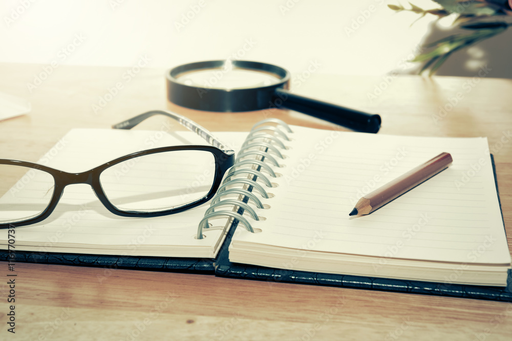 Open Blank notebook and pencil with magnifying glasses and Open Blank notebook and pencil with magnifying glasses and