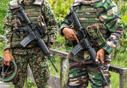 Two unrecognised malaysian soldiers holding their assault rifles