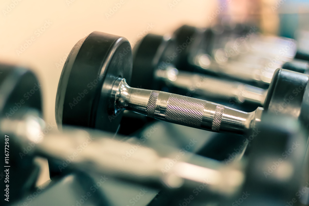 Soft focus the Sport equipment concept dumbbells on rack in fitn Soft focus the Sport equipment concept dumbbells on rack in fitn