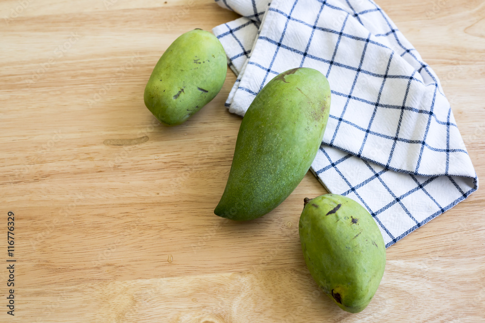 Whole Green Mango on a wooden table.In selective focus. Whole Green Mango on a wooden table.In selective focus.