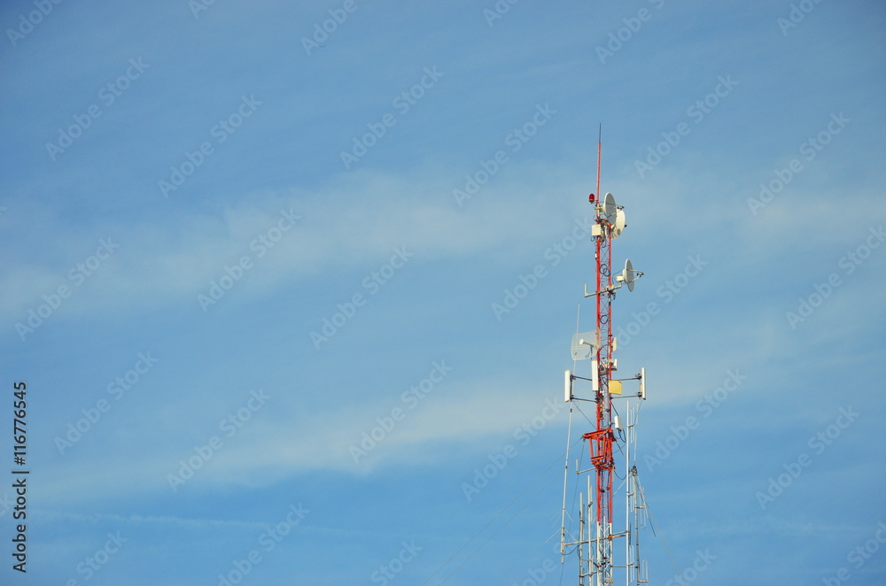 radio pole (telecommunication antenna) on blue sky and soft clouds background