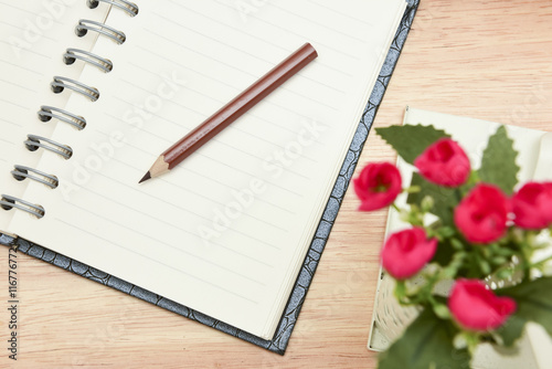 Pencil and open notebook on wood background in selective focus. © 15Studio