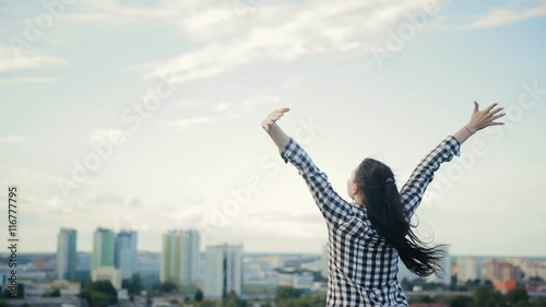 girl puts his hands to the sides and on the roof enjoys life
