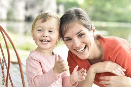 Portrait of cheerful mom and daughter laughing outloud photo