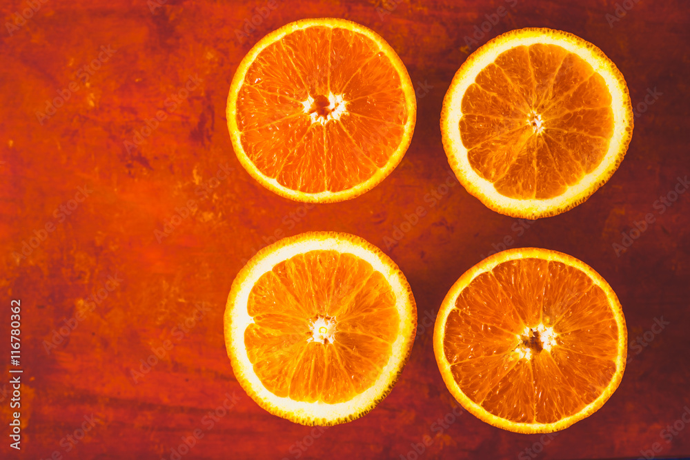 Orange slices on the terracotta background top view Orange slices on the terracotta background top view