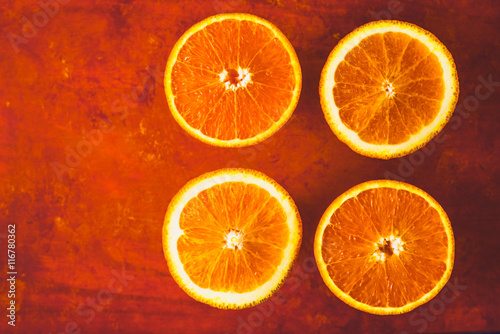 Orange slices on the terracotta background top view