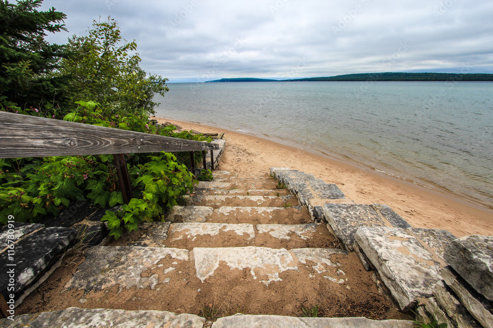 Stairs To A Beautiful Sandy Beach In Michigan. Winding stone stairs lead to a sandy beach on the shores of Lake Superior in Michigan's Upper Peninsula. Hiawatha National Forest. Munising, Michigan.