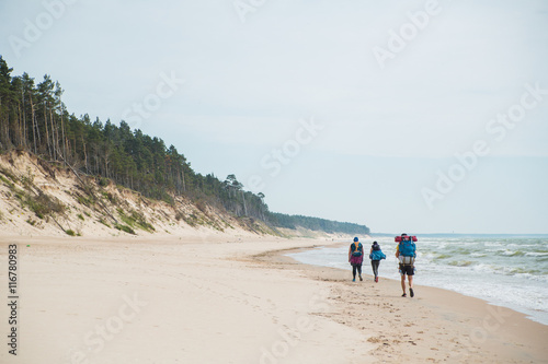 Travelers hiking tour on the sea coastline in summer time.