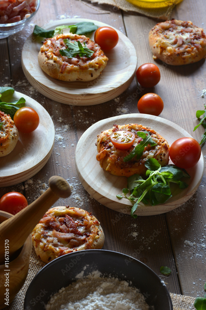 Rustic table with mini pizzas of bacon