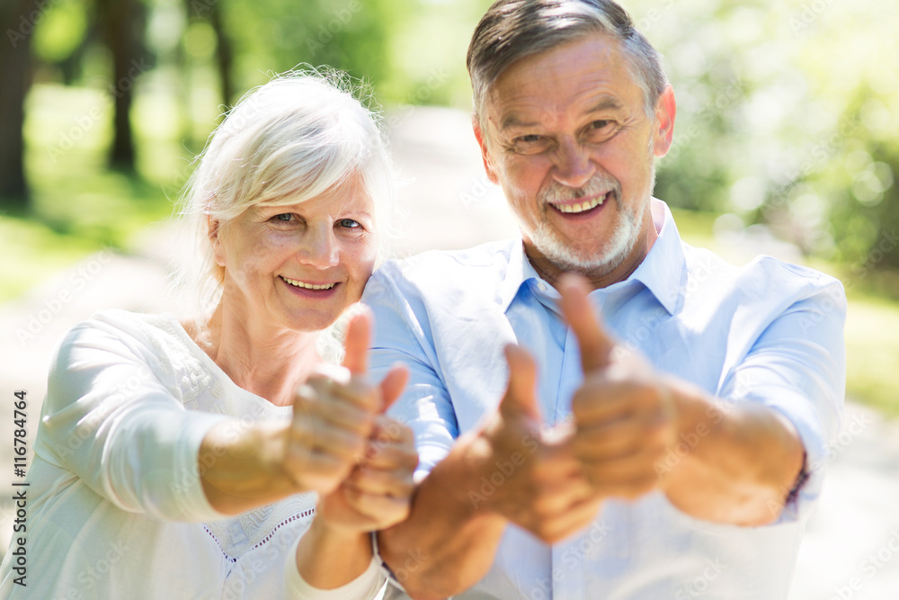 Senior couple showing thumbs up
