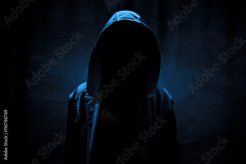 Woman wearing hoodie hiding in the dark,Scary background for book cover