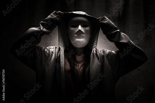 A stranger woman wearing hoodie with white mask hiding in the dark,Scary background for book cover