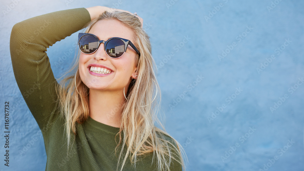 Stylish young woman in sunglasses smiling - obrazy, fototapety, plakaty 